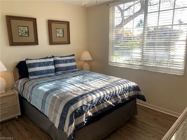 a large bed sitting in a bedroom next to a window