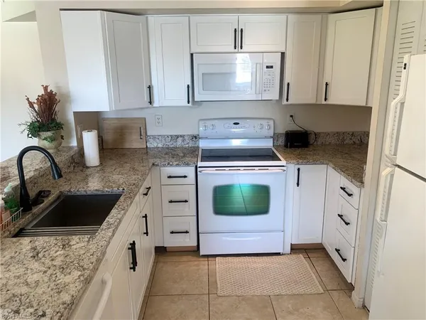 a kitchen with a stove sink and cabinets