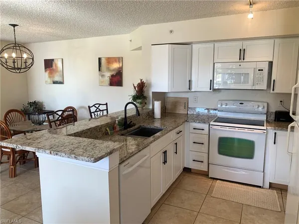 a kitchen with stainless steel appliances granite countertop a sink a stove and cabinets