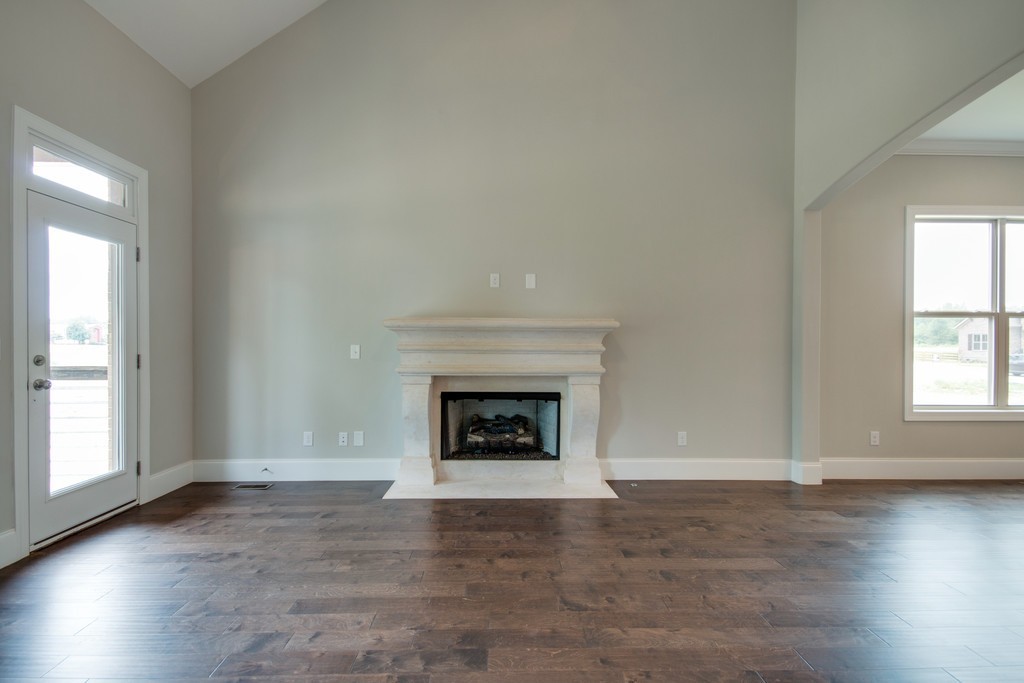 938 Hunters Lane Springfield, TN 37172 - Photo 12 of 29 an empty room with wooden floor fireplace and windows