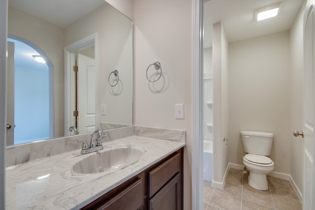 938 Hunters Lane Springfield, TN 37172 - Photo 28 of 29 a bathroom with a granite countertop sink a toilet and a mirror