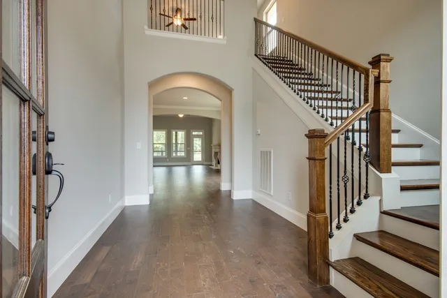 a view of staircase with wooden floor and a chandelier