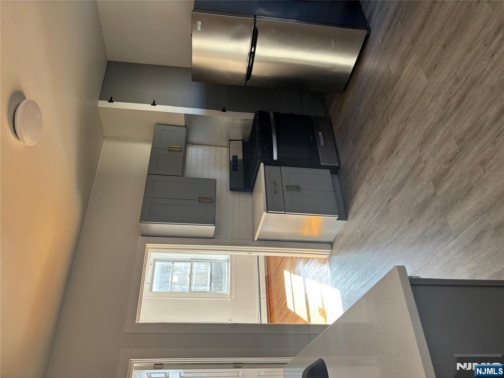 86 Center Street, Unit 3F Clifton, NJ 07011 - Photo 4 of 8 a kitchen with stainless steel appliances granite countertop a refrigerator a sink a stove a microwave a counter space and cabinets