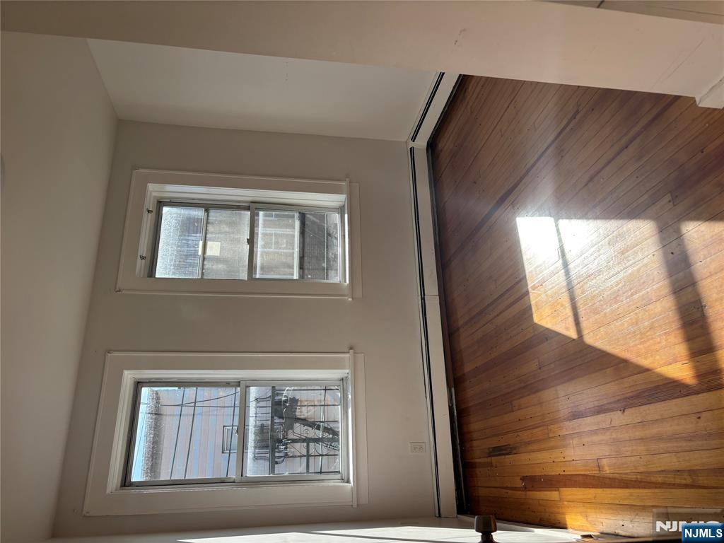 86 Center Street, Unit 3F Clifton, NJ 07011 - Photo 6 of 8 an empty room with wooden floor and windows