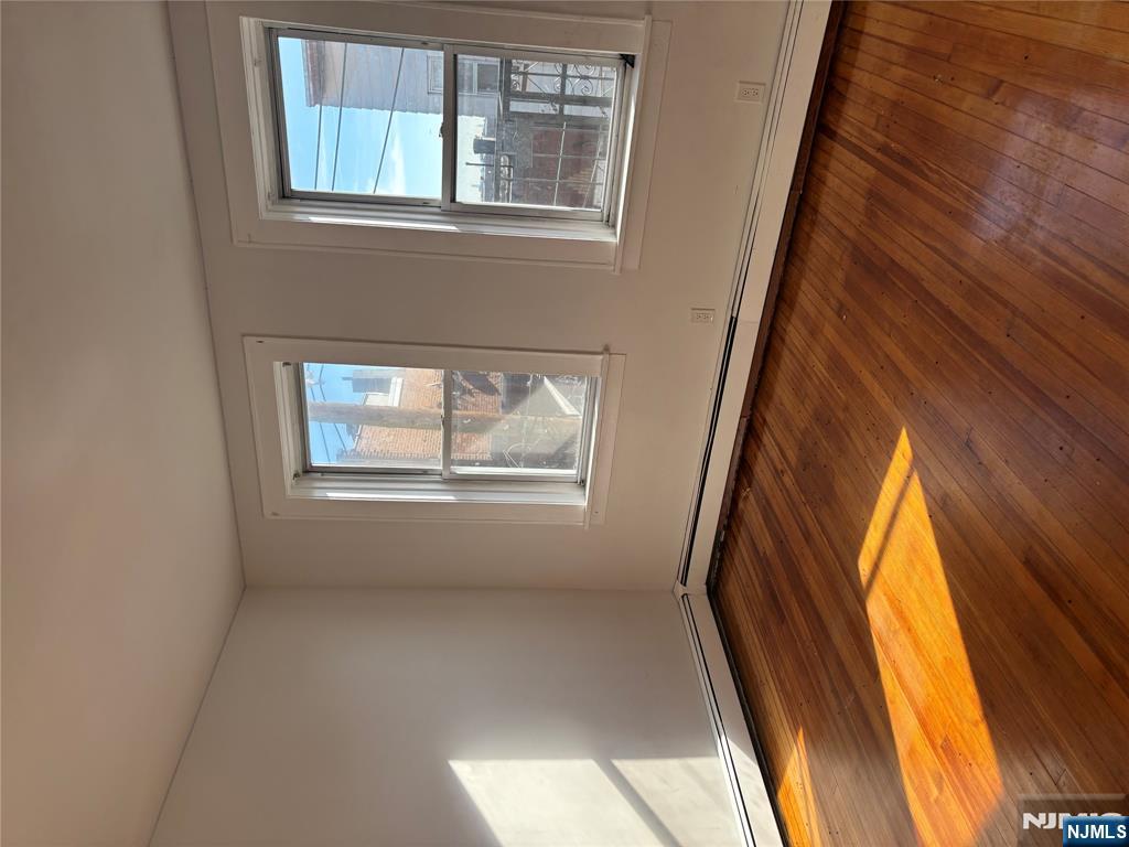 86 Center Street, Unit 3F Clifton, NJ 07011 - Photo 7 of 8 a view of an empty room with wooden floor and a window