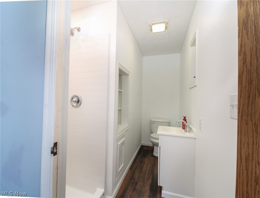 1502 Stone Quarry Road Fleming, OH 45729 - Photo 15 of 31 Primary bathroom with hardwood / wood-style floors, vanity, toilet, and a shower