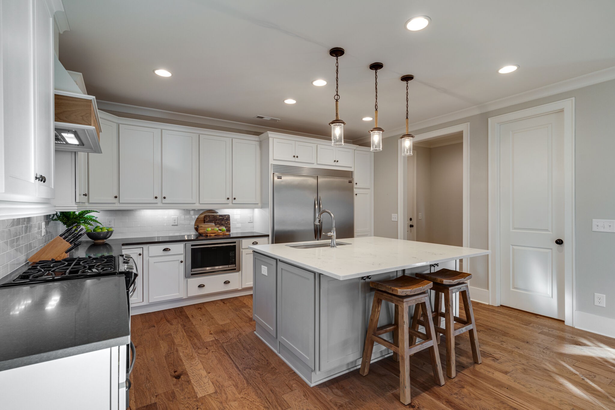 136 Vanner Road Mount Juliet, TN 37122 - Photo 12 of 55 a kitchen with a stove a sink dishwasher a refrigerator and white cabinets with wooden floor