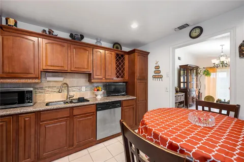 a kitchen with stainless steel appliances granite countertop a sink dishwasher and cabinets with wooden floor
