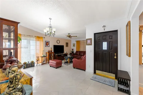 a living room with furniture a chandelier and a flat screen tv