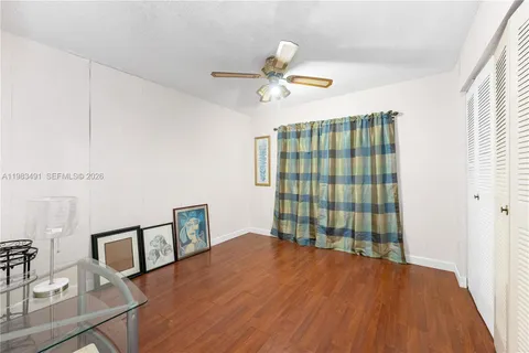 a view of a livingroom with wooden floor and a ceiling fan