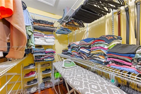 a view of walk in closet with clothes and shoes
