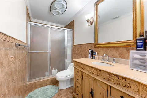 a bathroom with a granite countertop sink mirror vanity and toilet