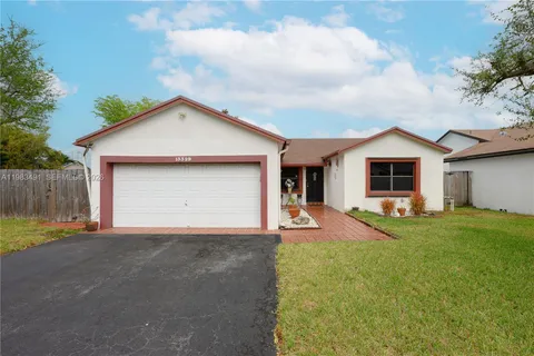 a view of a house with a yard and fence