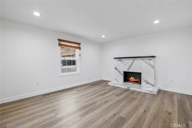 an empty room with a fireplace and wooden floor