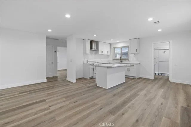 a large kitchen with stainless steel appliances granite countertop a large stove a sink dishwasher and a refrigerator with wooden floor