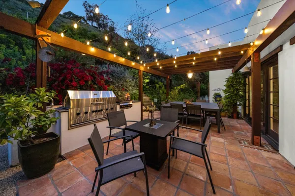 a view of a patio with a dining table and chairs with potted plants and a tables