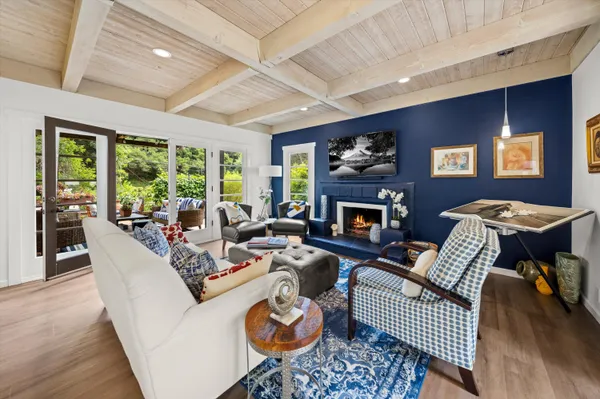 a living room with furniture fireplace and a large window