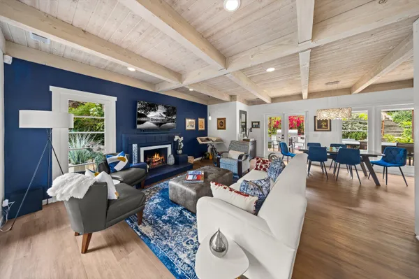 a living room with furniture a fireplace a rug and a window