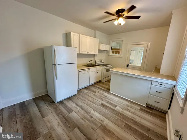 a kitchen with a refrigerator and a stove top oven