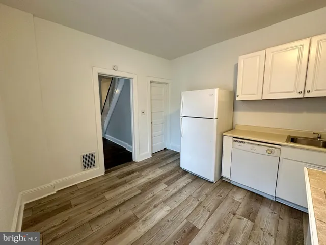 a kitchen with a refrigerator and white cabinets