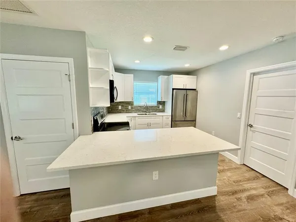 a kitchen with a refrigerator sink and cabinets