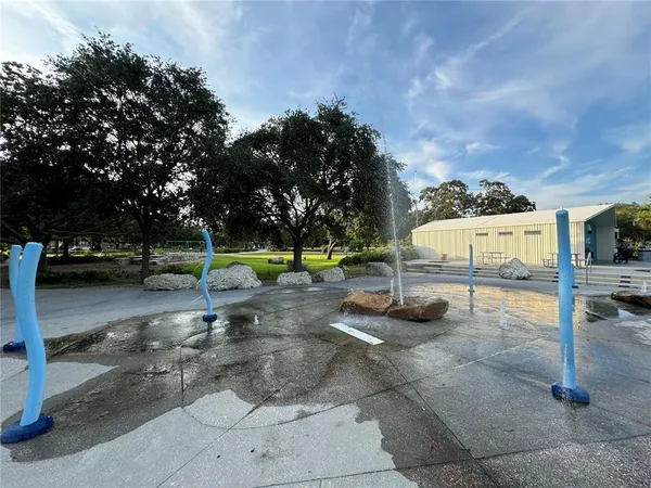 a view of a swimming pool with a big yard and large trees