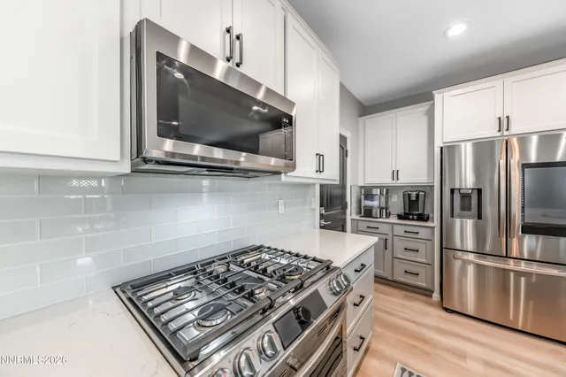 a kitchen with stainless steel appliances a sink a stove a microwave and cabinets