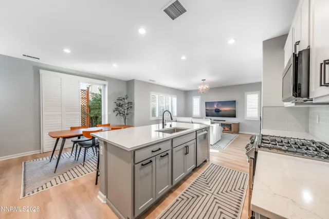 a large kitchen with stainless steel appliances granite countertop a sink stove and refrigerator