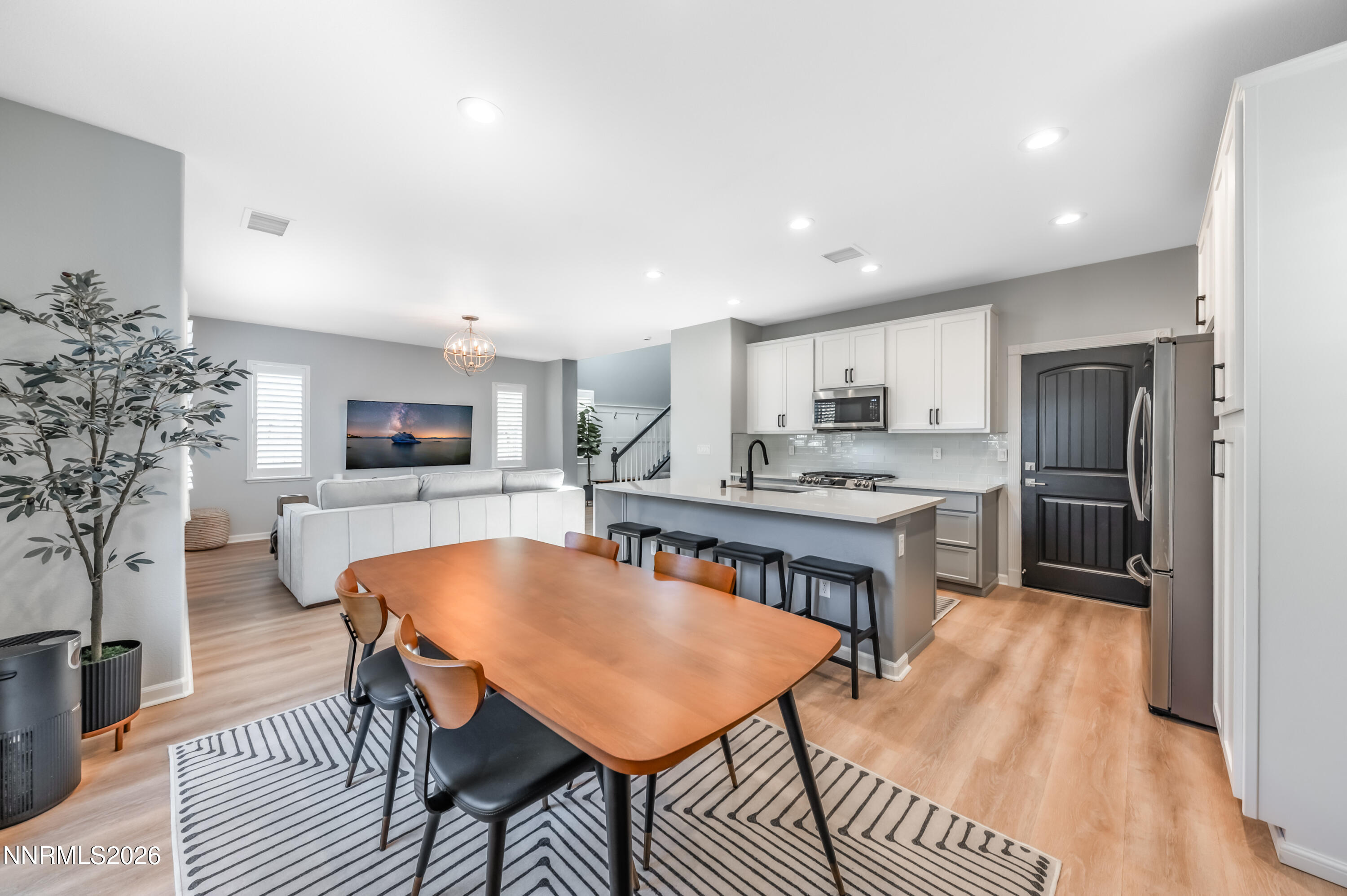 9530 Vikingholm Road Reno, NV 89521 - Photo 15 of 42 a kitchen with stainless steel appliances granite countertop a refrigerator a sink a stove a dining table and chairs with wooden floor