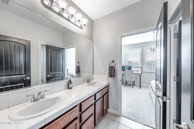 a en suite bathroom with double vanity a mirror and a shower