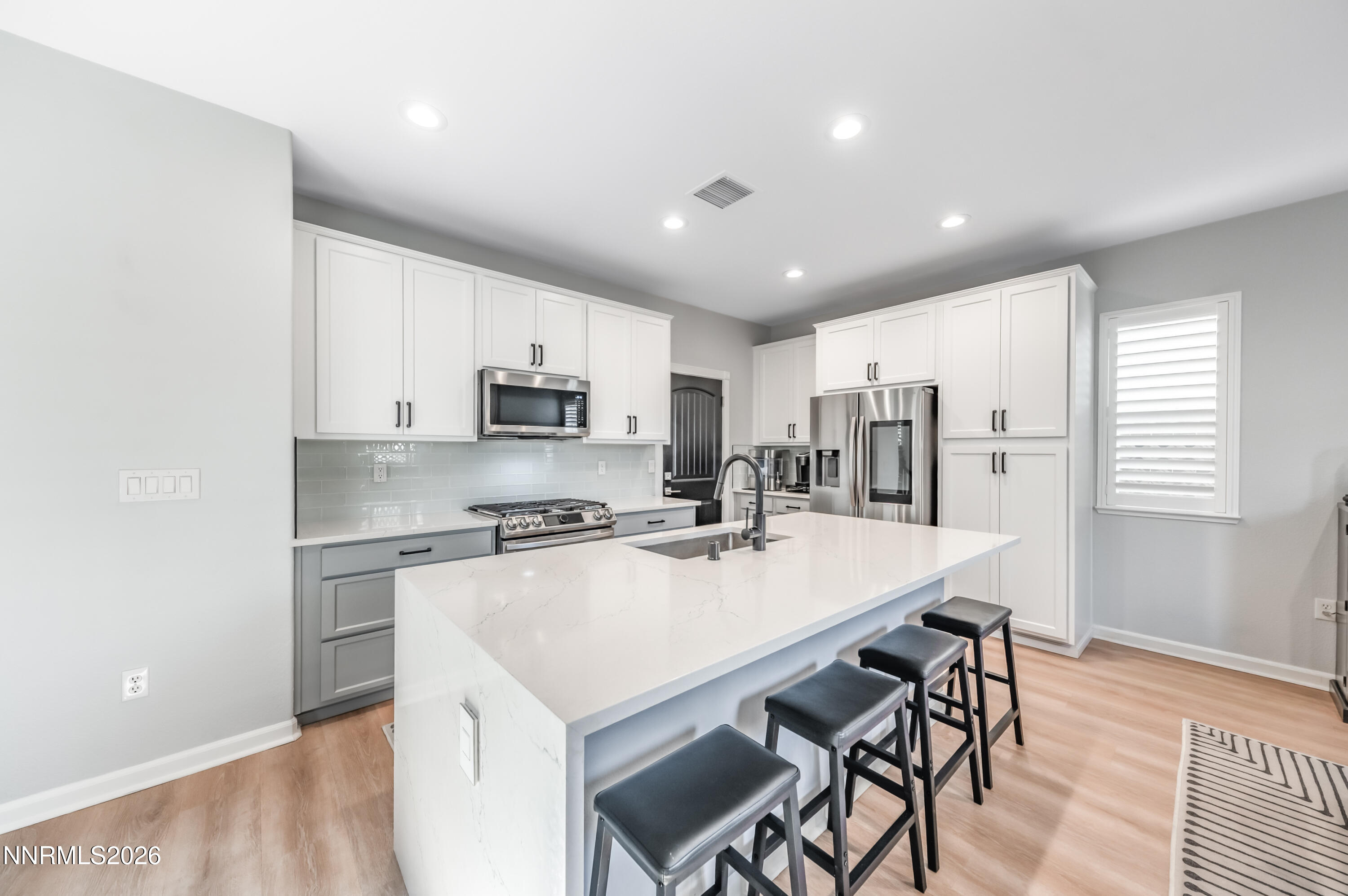 9530 Vikingholm Road Reno, NV 89521 - Photo 8 of 42 a kitchen with stainless steel appliances granite countertop a stove a refrigerator a sink a dining table and chairs