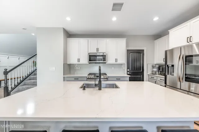 a kitchen with kitchen island a large counter top stainless steel appliances and cabinets