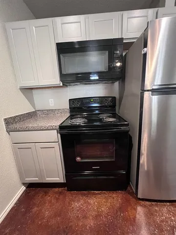 a kitchen with white cabinets and stainless steel appliances