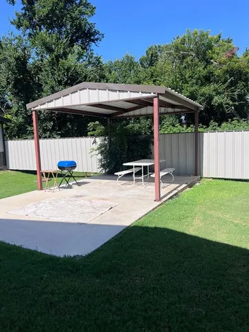 a view of backyard with swimming pool and wooden fence