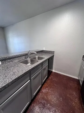 a kitchen with granite countertop a sink and a stove