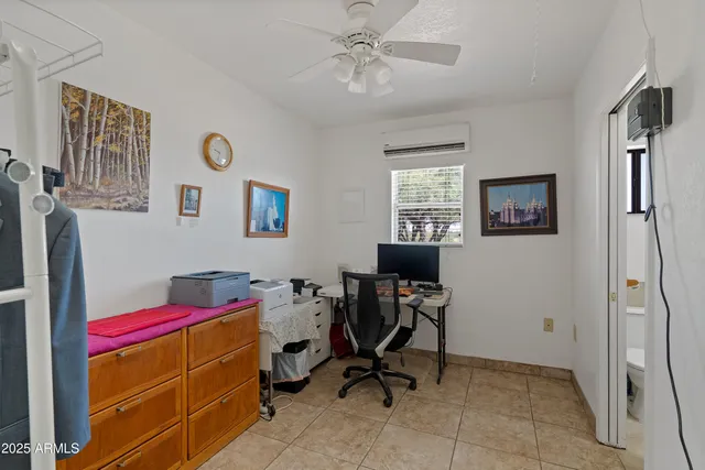 a view of a workspace with furniture and a window
