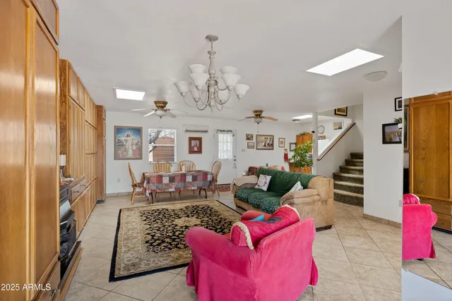 a living room with furniture chandelier and a view of kitchen