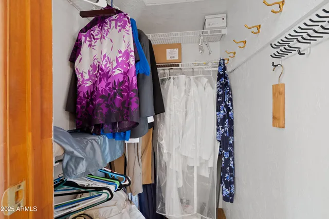 a view of walk in closet with clothes