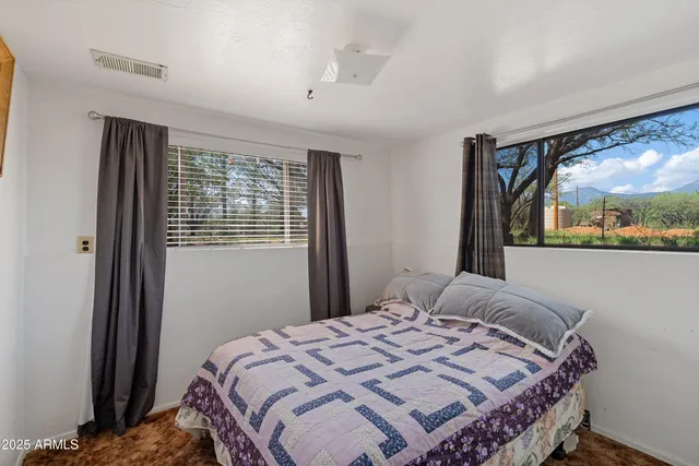 a bedroom with a bed and a large window