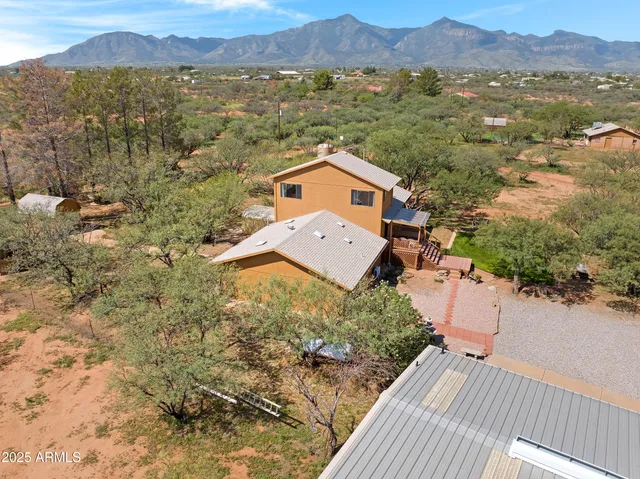 an aerial view of residential houses with outdoor space and trees