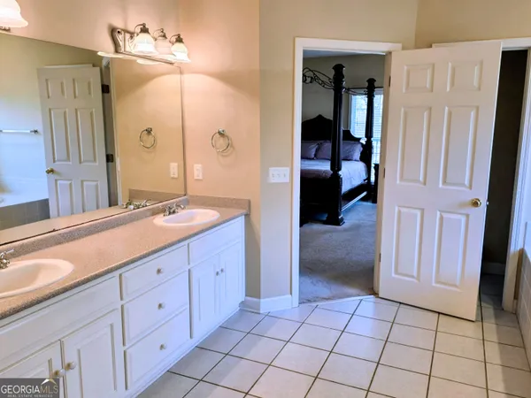 a spacious bathroom with a granite countertop sink a mirror and a shower