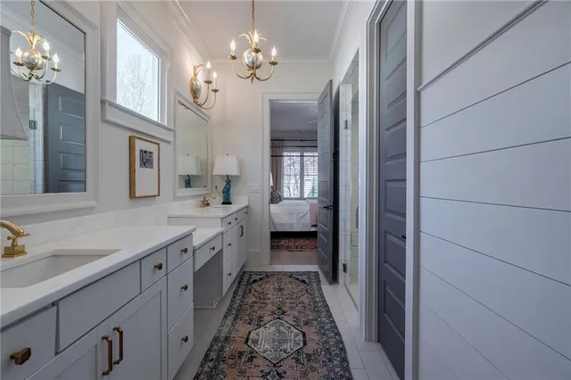 a spacious en suite bathroom with a double vanity sink and a mirror
