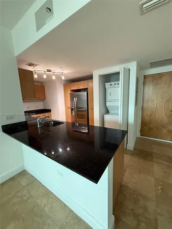a kitchen with a sink a counter space and cabinets