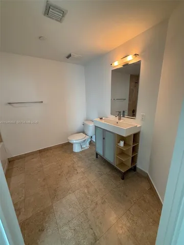 a spacious bathroom with a sink a toilet and a mirror