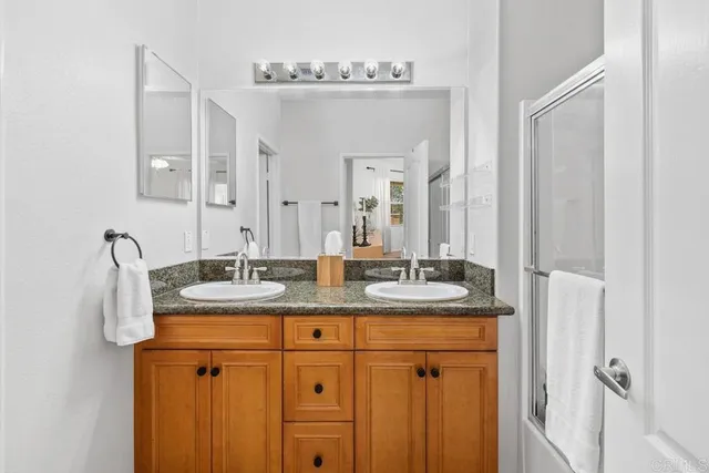 a bathroom with a granite countertop sink a mirror and a vanity