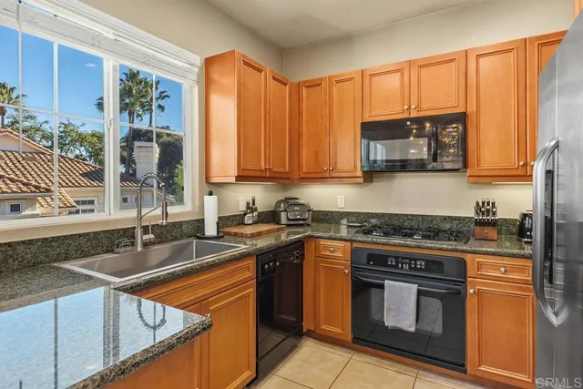 a kitchen with stainless steel appliances granite countertop a stove sink and cabinets