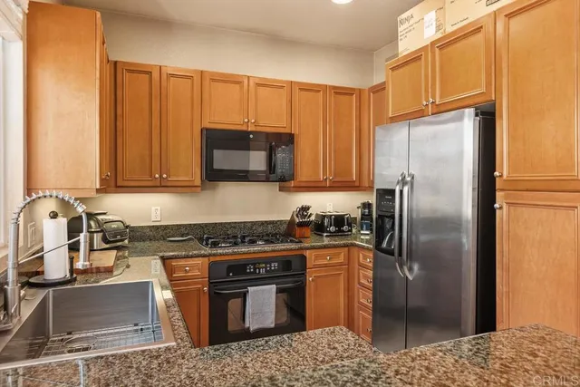 a kitchen with stainless steel appliances granite countertop a refrigerator stove and sink
