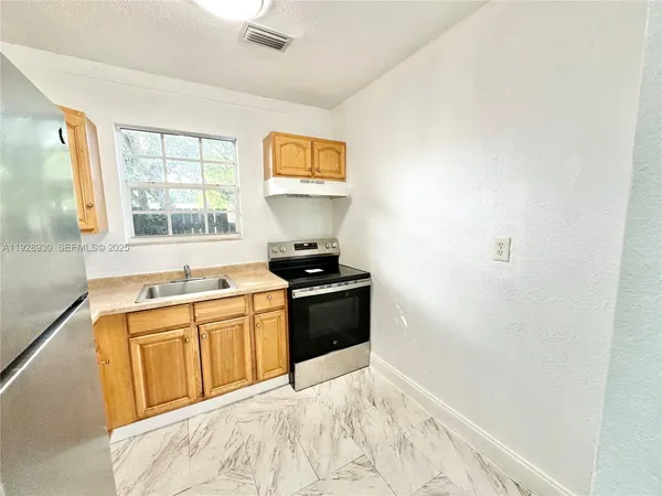 a kitchen with a stove a sink and a window