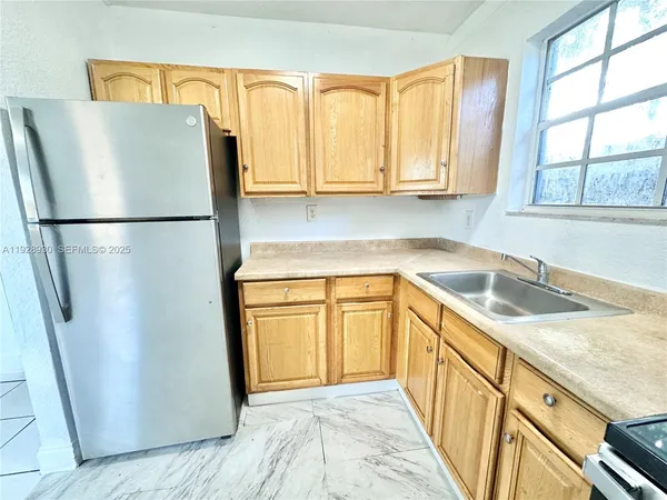 a kitchen with stainless steel appliances granite countertop a refrigerator and a sink