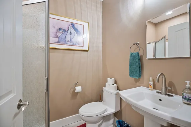 a bathroom with a toilet sink and mirror